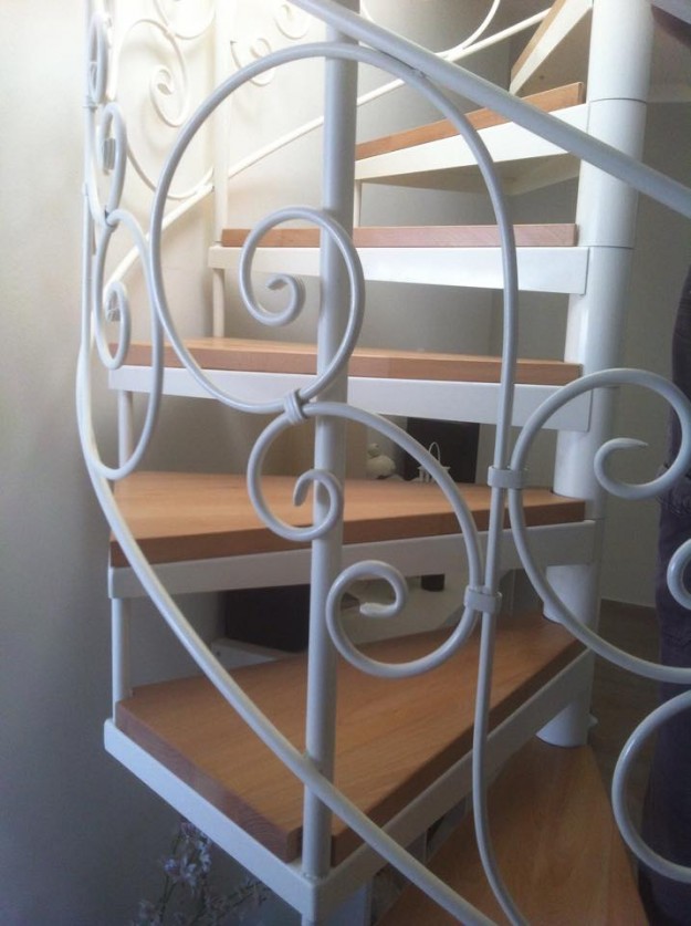 מדרגות לוליניות (ספירליות) עם מעקה מעוטר, וחיפוי עץ בוק.