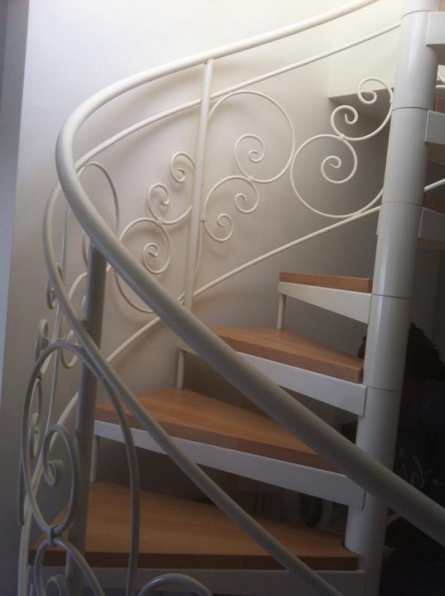 מדרגות לוליניות (ספירליות) עם מעקה מעוטר, וחיפוי עץ בוק.