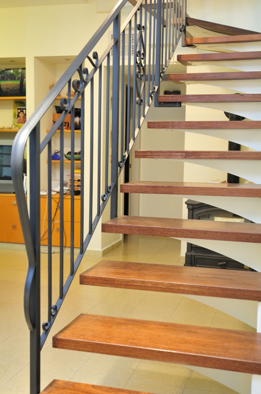 מדרגות מדורגות מברזל, חיפוי עץ ומעקה מתכת.