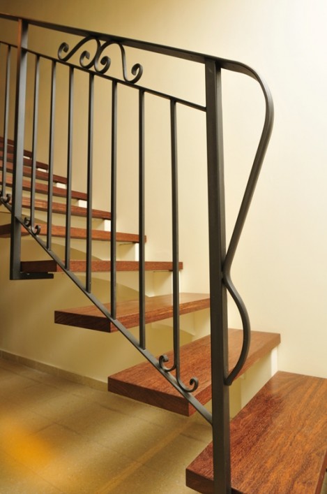 מדרגות מדורגות מברזל, חיפוי עץ ומעקה מתכת.