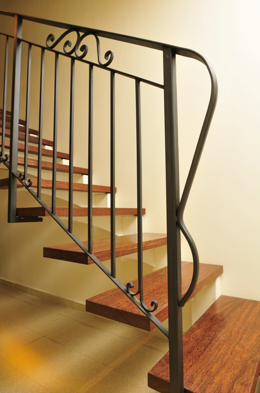 מדרגות מדורגות מברזל, חיפוי עץ ומעקה מתכת.